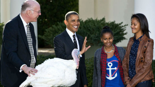 President Obama pardons cobbler the turkey on Thanksgiving with his daughters Sasha and Malia.