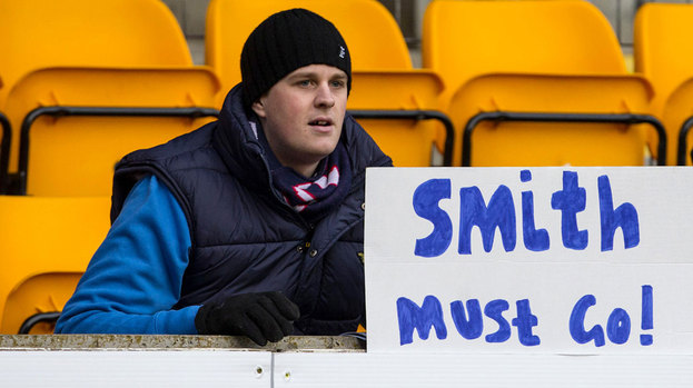A Dundee supporter holds a banner at the match.